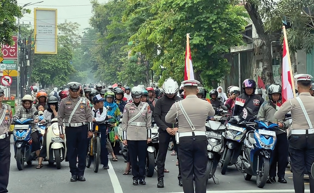 PERINGATI HARI PAHLAWAN: Petugas Satlantas, Kosti, dan pengguna jalan mengheningkat cipta di Perempatan Jayastamba Nganjuk kemarin.
