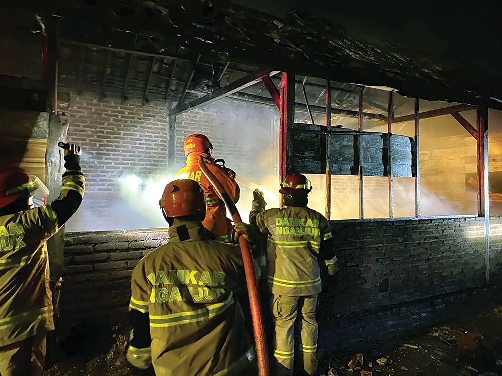 MEMBARA: Petugas Damkarmat Nganjuk memadamkan api yang melalap oven jagung milik warga Desa Senggowar, Kecamatan Gondang.