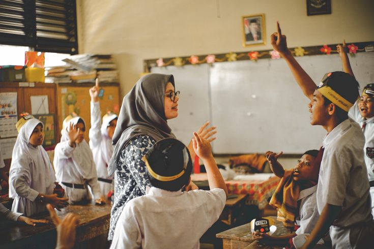 Guru berinteraksi dengan murid di kelas