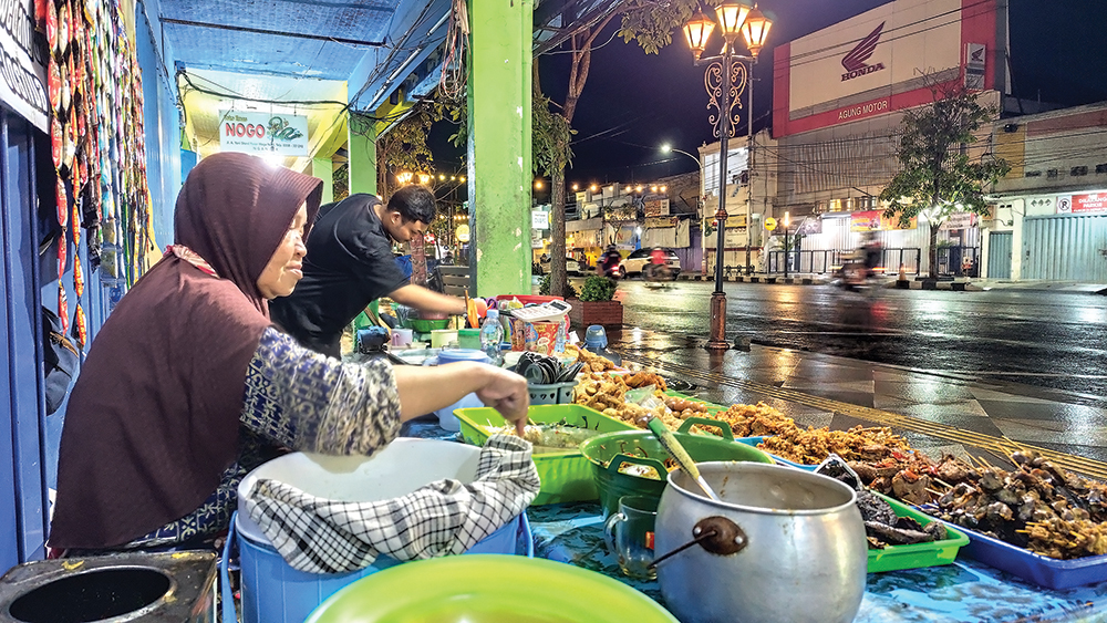 MUSIM PENGHUJAN: Penjual pecel di Jalan Ahmad Yani menunggu pembeli saat sore hari.