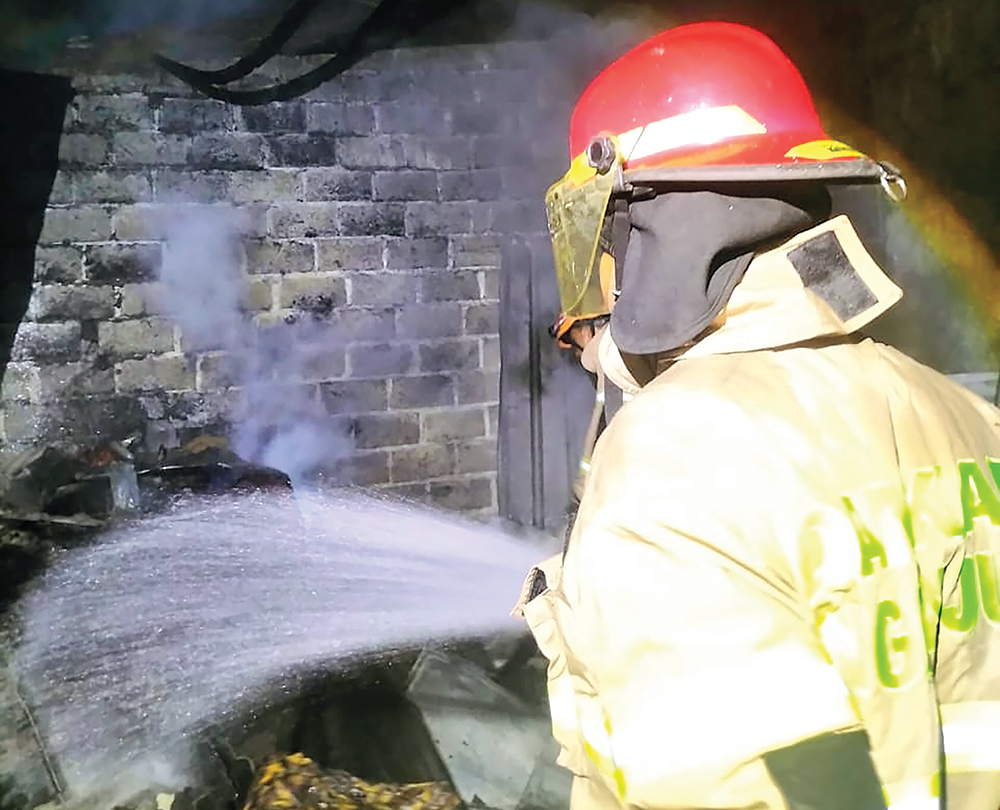 PADAMKAN API: Petugas Damkarmat Nganjuk menyemprot si jago merah yang melalap dapur rumah warga Prambon kemarin.