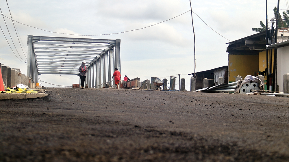 PENGASPALAN: Warga  melintas di Jembatan Kutorejo, Kecamatan Bagor kemarin. Jembatan penghubung Kecamatan Rejoso - Bagor ditargetkan selesai akhir November 2025 karena peranannya sanga