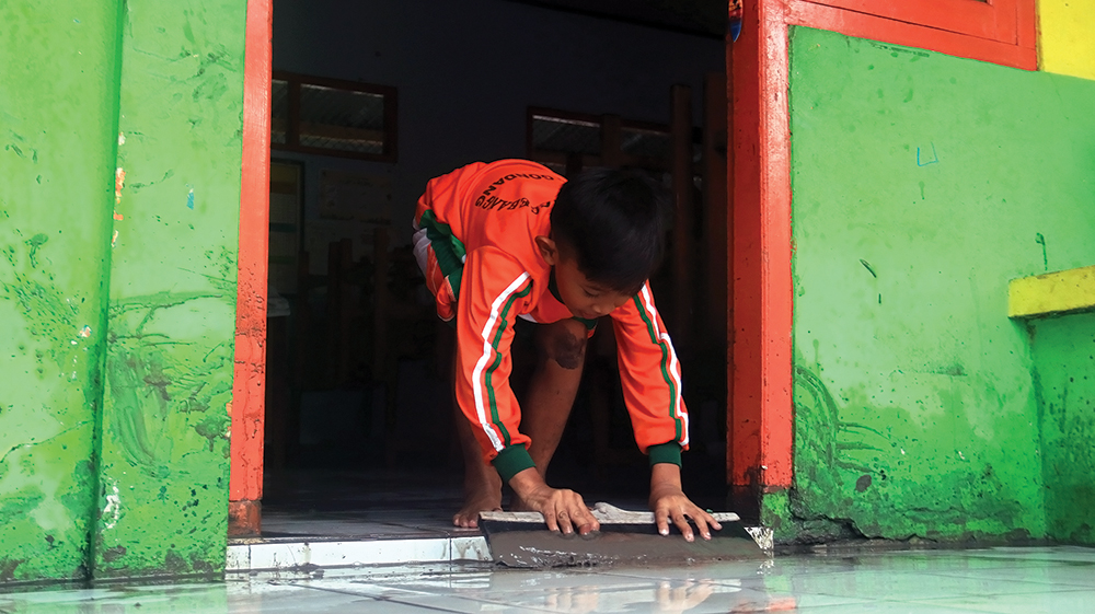 GANGGU KBM: Siswa SDN Balonggebang 1 membersihkan lumpur yang masuk ruang kelas saat banjir (19/11).
