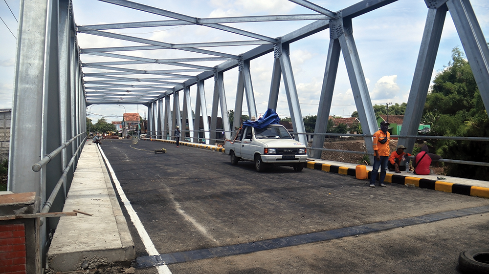 MULAI FINISHING: Pekerja proyek mengecat trotoar Jembatan Kutorejo, Kecamatan Bagor kemarin. Jembatan Kutorejo yang dibangun Pemerintah Provinsi Jawa Timur ditarget selesai akhir bulan