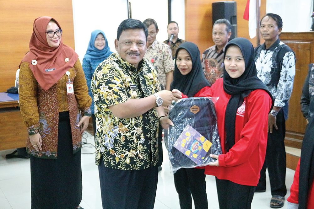 PEMBUKAAN: Bupati Marhaen Djumadi memberi peralatan pada peserta pelatihan menjahit dari Disnaker.