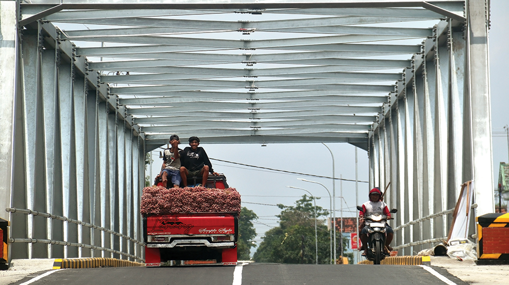TUNGGU PERESMIAN: Pengemudi pikap dan pengendara motor melintas di Jembatan Kutorejo, Kecamatan Bagor kemarin. jembatan yang dibangun Pemprov Jatim ini hanya menunggu peresmian.
