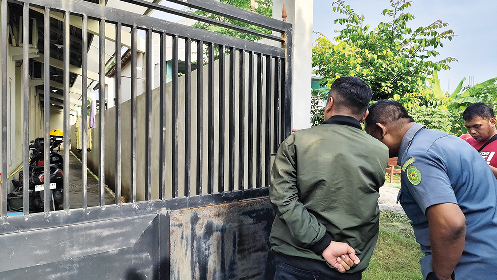 TKP PEMBUNUHAN: Tetangga korban melihat kamar kos yang menjadi tempat pembunuhan ibu dan anak di Kelurahan Payaman, Kecamatan Nganjuk kemarin.