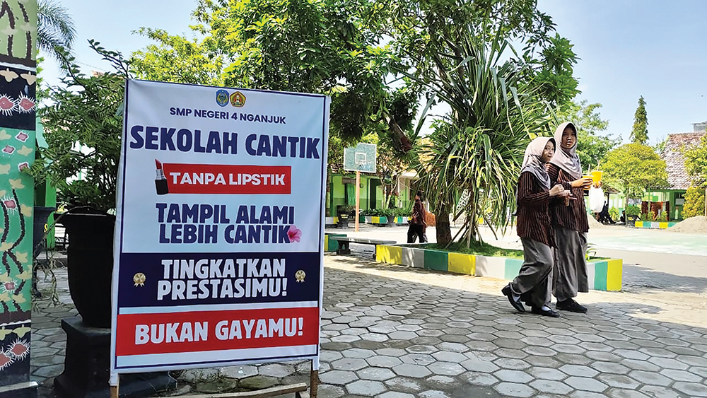 PRESTASI LEBIH PENTING: Larangan siswi SMP memakai lipstik dipasang di halaman SMPN 4 Nganjuk. Siswi diminta fokus pada peningkatan prestasi daripada penampilan.