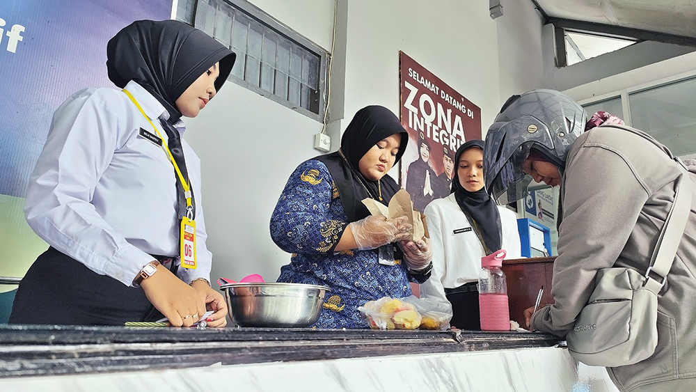 CEK MAKANAN: Petugas membuka makanan yang dibawa pembesuk untuk warga binaan di Rumah Tahanan Nganjuk kemarin.