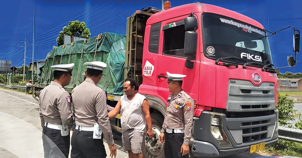 BERBAHAYA: Petugas Satlantas Polres Nganjuk menegur sopir truk yang parkir sembarangan di tepi jalan raya Kertosono-Wilangan.