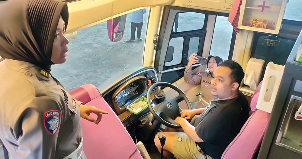 CEK BUS PARIWISATA: Petugas Satlantas Polres Nganjuk mengecek kondisi bus pariwisata yang akan digunakan untuk berwisata saat libur Natal dan Tahun Baru 2026. Pengecekan kendaraan
