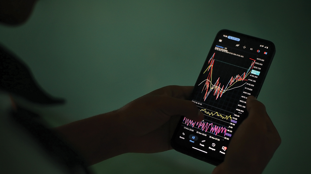 MAIN TRADING: Ren memantau pergerakan candlestick di HP.
