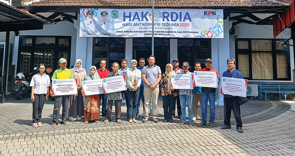 BANTU WARGA: Kepala DPRKPP Kabupaten Nganjuk Mashudi Nurul Huda foto bersama penerima bantuan sosial perbaikan rumah karena bencana dari DPRKPP Nganjuk.