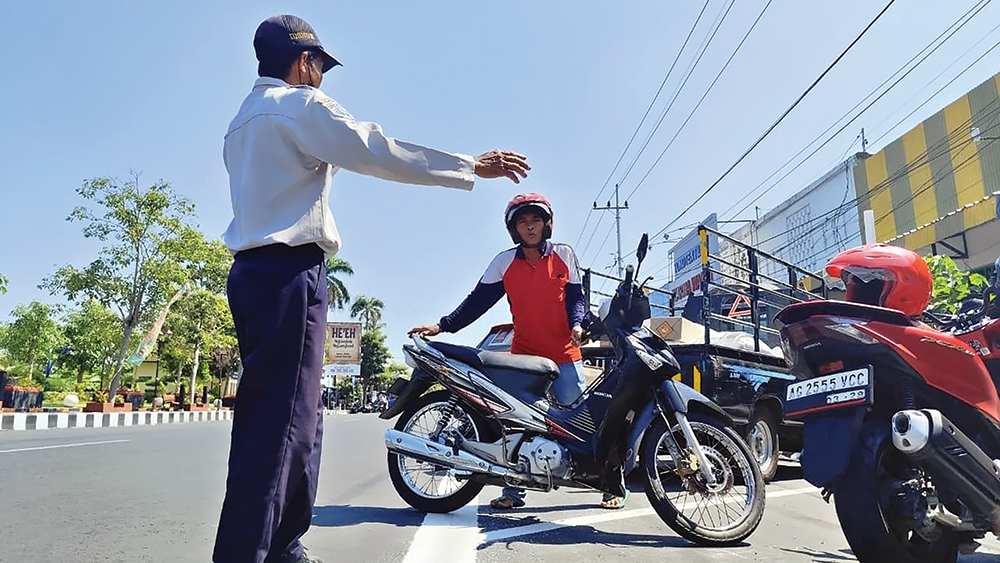SUMBER PAD: Jukir menata parkir di Jalan Ahmad Yani Nganjuk. Retribusi parkir menjadi salah satu sumber PAD Kota Angin.