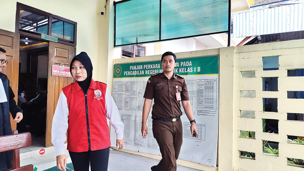 TERTUNDA: Tri Ratna Muliya keluar ruang sidang. Sidang dengan agenda saksi ahli ditunda kemarin.