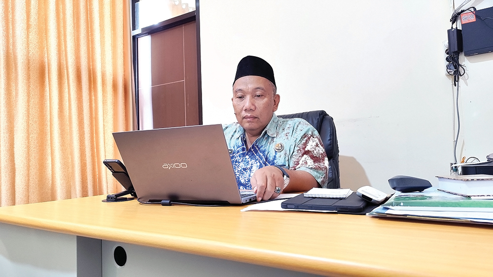 BARU: Kepala Kantor Kementerian Haji dan Umrah Kabupaten Nganjuk Zainal Abidin Hanif Kamaloddin mengecek data calon jemaah haji. Kantor Hanif masih numpang di kemenag.