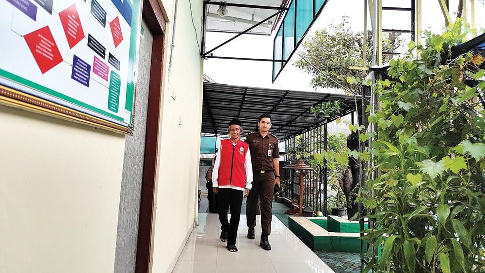 PEMBUNUH BERSEDIH: Atmorejo Sagi (kiri) keluar ruang sidang dengan dikawal petugas menuju ruang tahanan di Pengadilan Negeri Nganjuk kemarin.