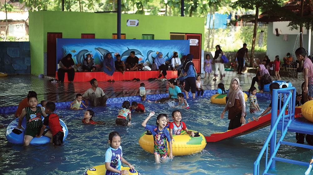 MEMBELUDAK: Anak-anak bermain air di kolam renang anak.