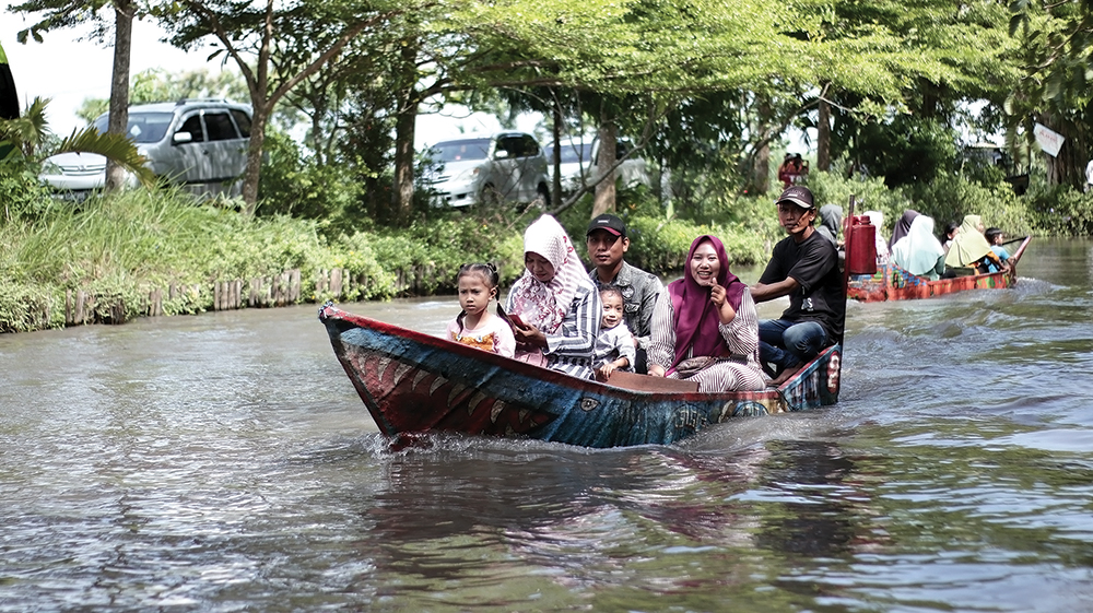 WISATA DESA: Pengunjung menikmati perahu wisata di Wisata Tani Betet saat libur Nataru.