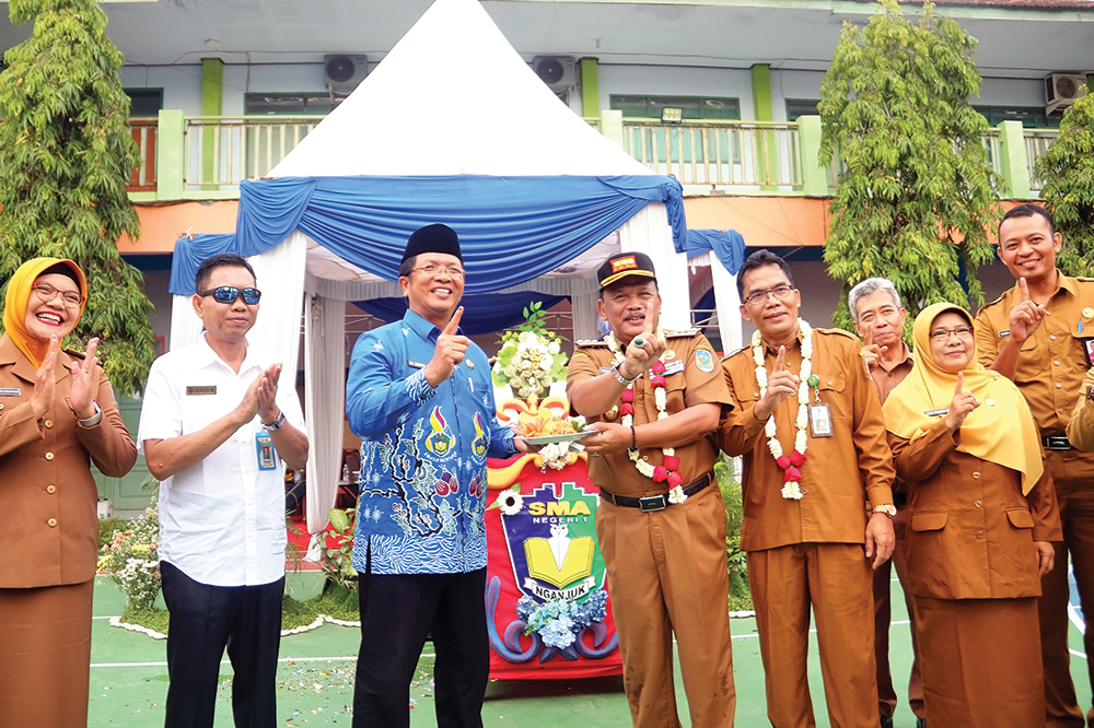 SMASA MENYALA: Bupati Marhaen Djumadi, Kacabdindik Jatim Wilayah Nganjuk M. Ardiyanto, dan Kepala SMAN 1 Nganjuk Sugiyono foto bersama setelah potong tumpeng.