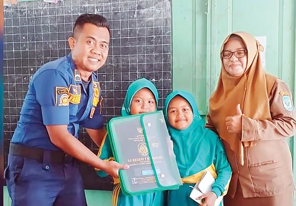 AMBIL RAPOR: Petugas Damkarmat Nganjuk membantu siswa mengambil rapor di sekolah karena ayahnya berhalangan hadir.