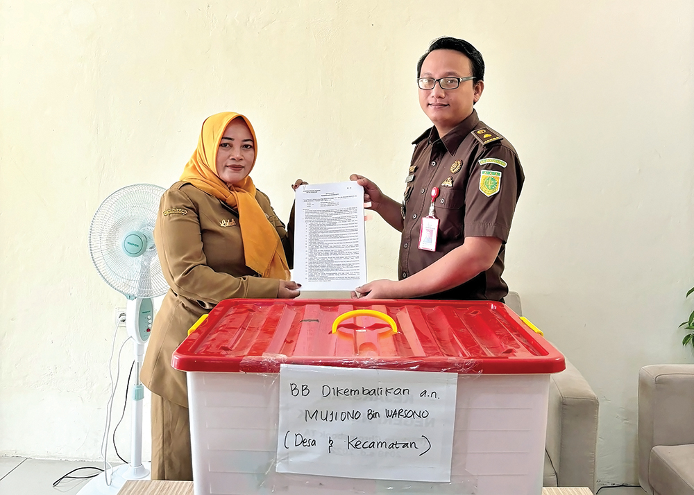 EKSEKUSI: Kepala Seksi Tindak Pidana Khusus Kejari Nganjuk Yan Aswari menyerahkan barang bukti korupsi Dana Desa Banaran  Kulon.