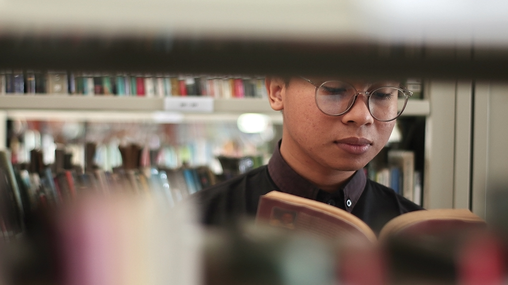 KUTU BUKU: Salah satu pengunjung perpustakaan membaca buku. Setahun pengunjung mencapai 150 ribu orang.