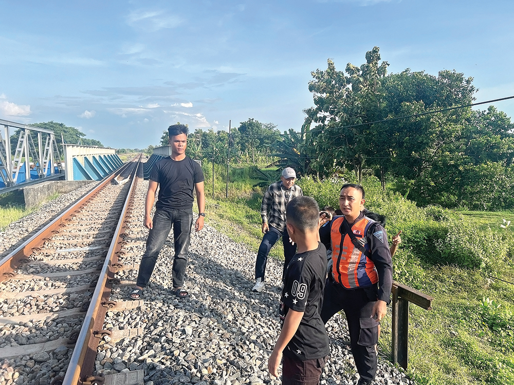 BERBAHAYA: Petugas KAI menangkap dua bocah yang diduga melempar kereta api di Kelurahan Mangundikaran, Nganjuk.