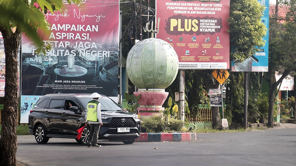 VITAL: Pengemudi melintas di sekitar Tugu Asmaul Husna, Warujayeng. Perbaikan jalan tahu ini hanya 100 kilometer.