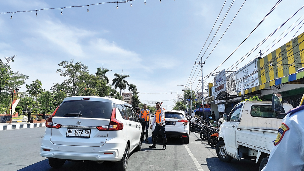 RETRIBUSI NAIK: Petugas parkir menata mobil. Retribusi parkir naik .