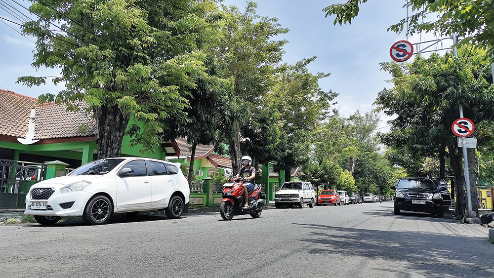 PARKIR DUA SISI: Jalan Dermojoyo terasa sempit karena kendaraan parkir di sisi selatan dan utara jalan.