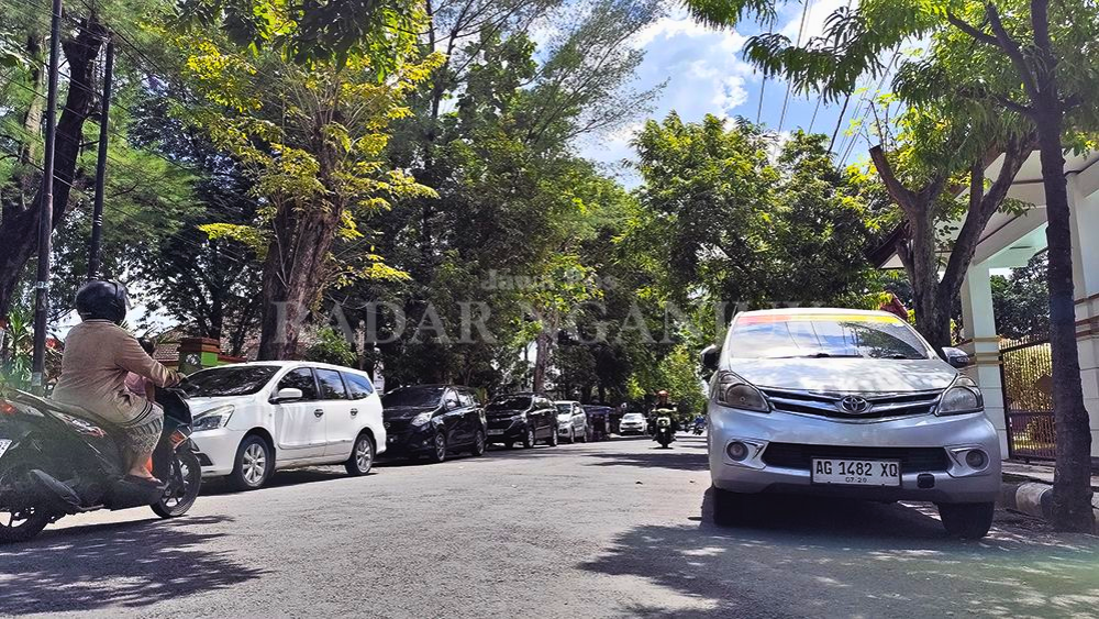 BIKIN SEMPIT: Kendaraan parkir di dua sisi membuat Jalan Dermojoyo Nganjuk macet saat jam masuk kantor.