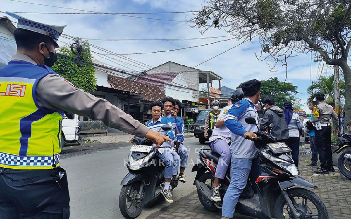 OPERASI SEMERU: Petugas menilang pelajar yang tidak memiliki SIM C saat mengendarai motor.