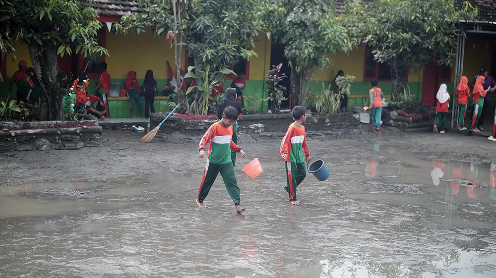 LANGGANAN BANJIR: Siswa SDN Balonggebang 1 membersihkan lumpur di kelas akibat banjir. Pemkab akan perbaiki saluran air.