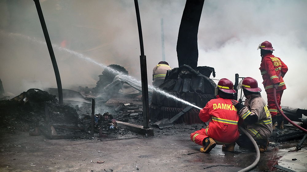 MEMBARA: Petugas damkarmat memadamkan si jago merah yang melalap gudang rongsokan di Ganungkidul kemarin.