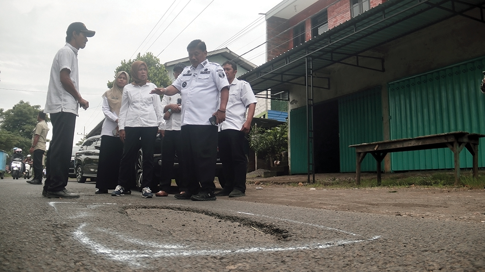 MENGANGA: Bupati Marhaen Djumadi mengecek lubang di Jalan Raya Warujayeng-Prambon.