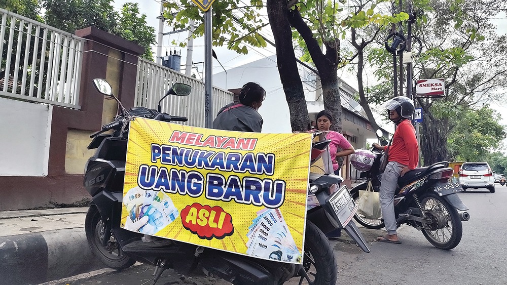 JADI BURUAN: Jasa penukaran uang baru di tepi jalan menjelang Lebaran.