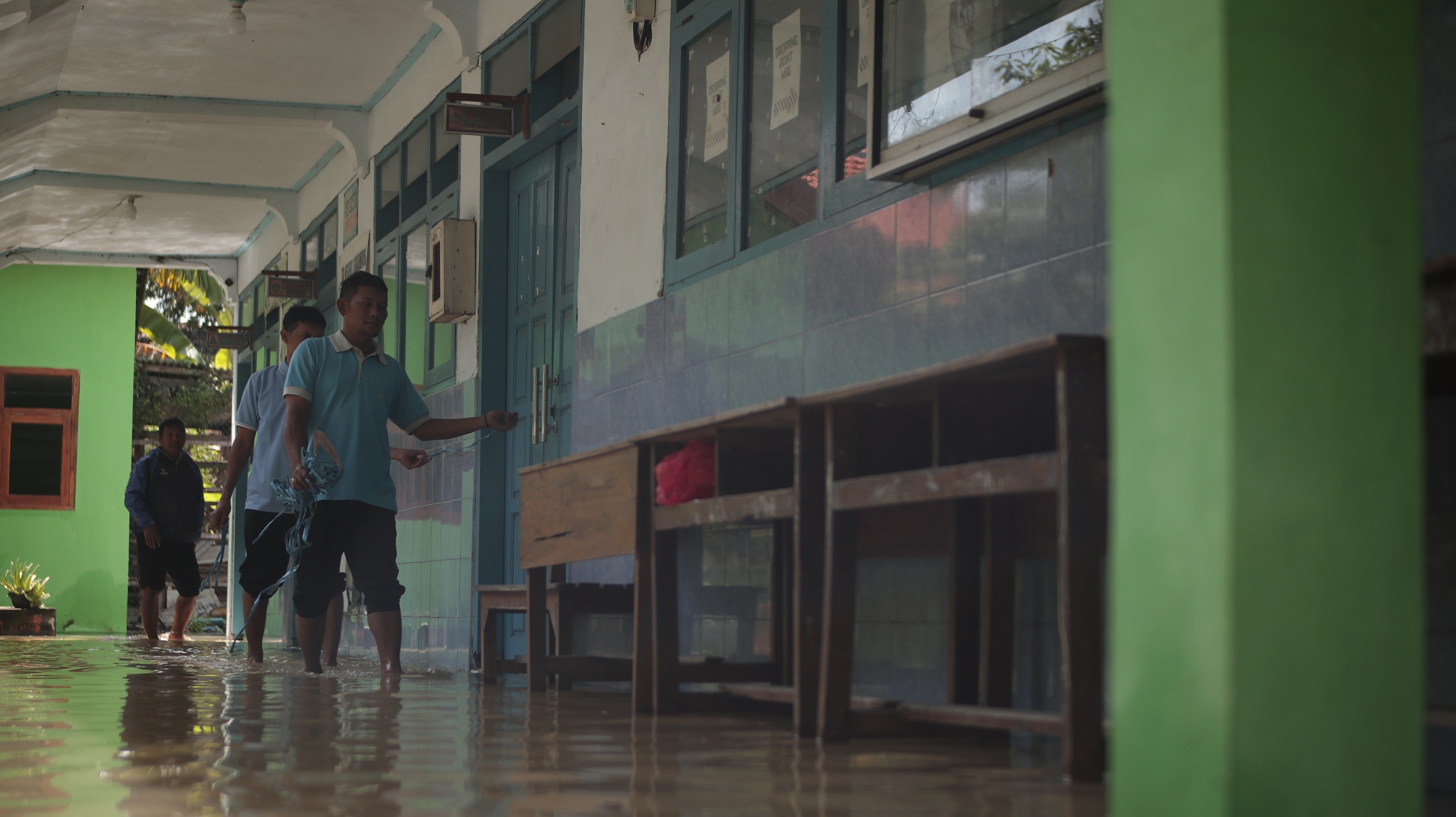 Seorang guru saat mengecek ruang guru di SDN 1 Sukomoro yang terdampak banjir