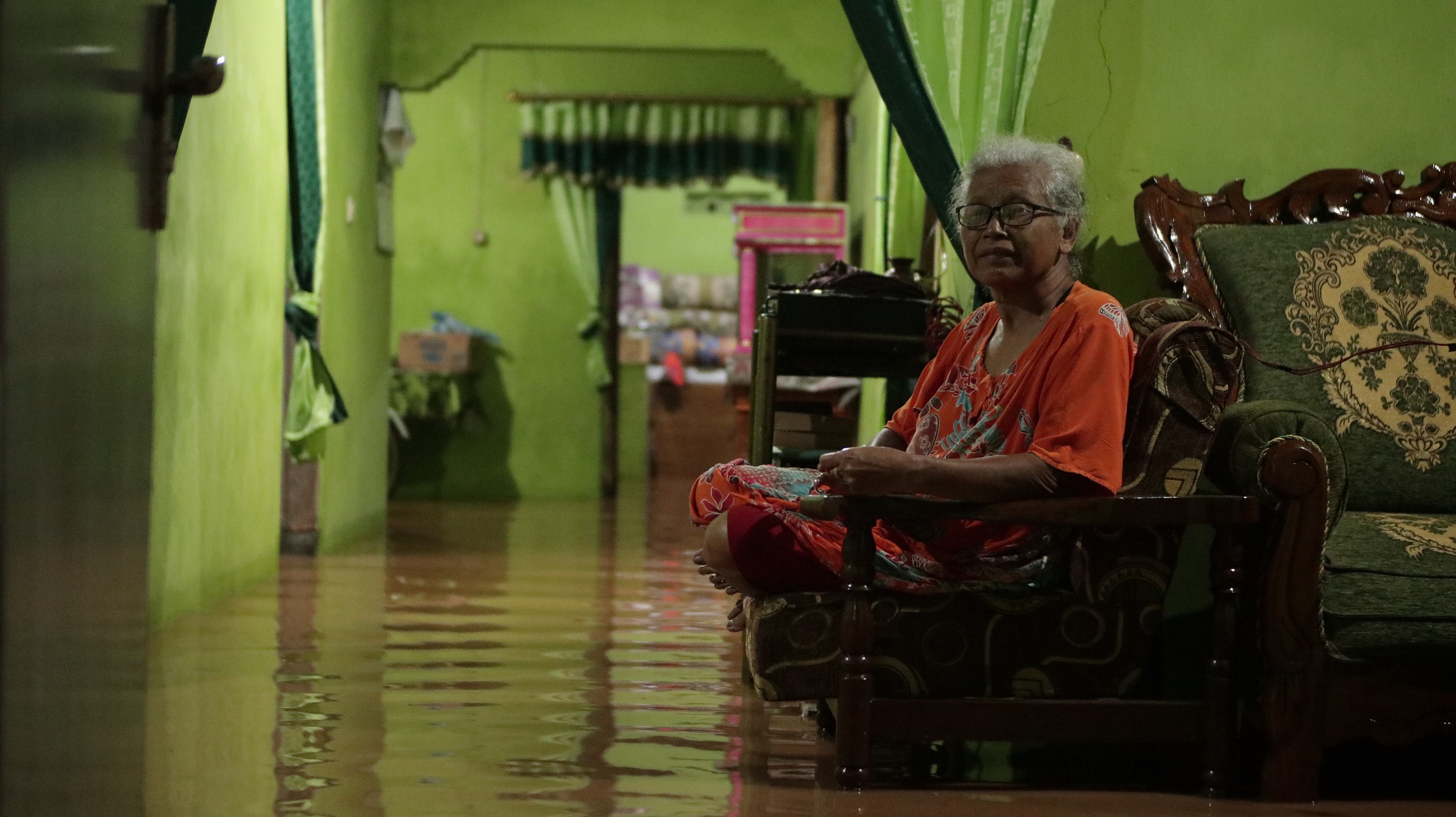 Warga Kelurahan Kapas saat menunggu banjir surut di rumahnya