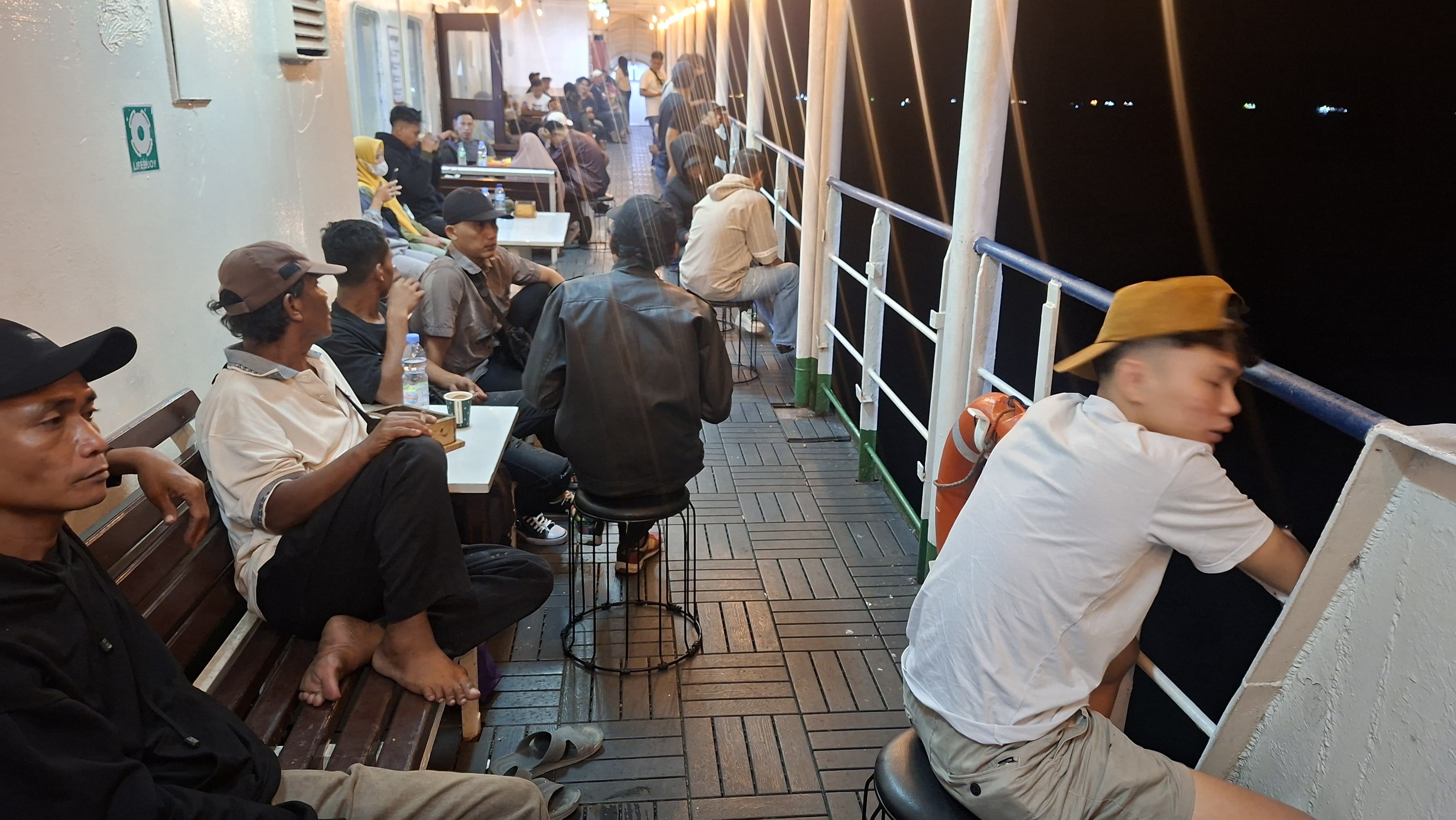 MEMBELAH SELAT SUNDA: Penumpang Kapal Ferry menikmati pergantian malam. 