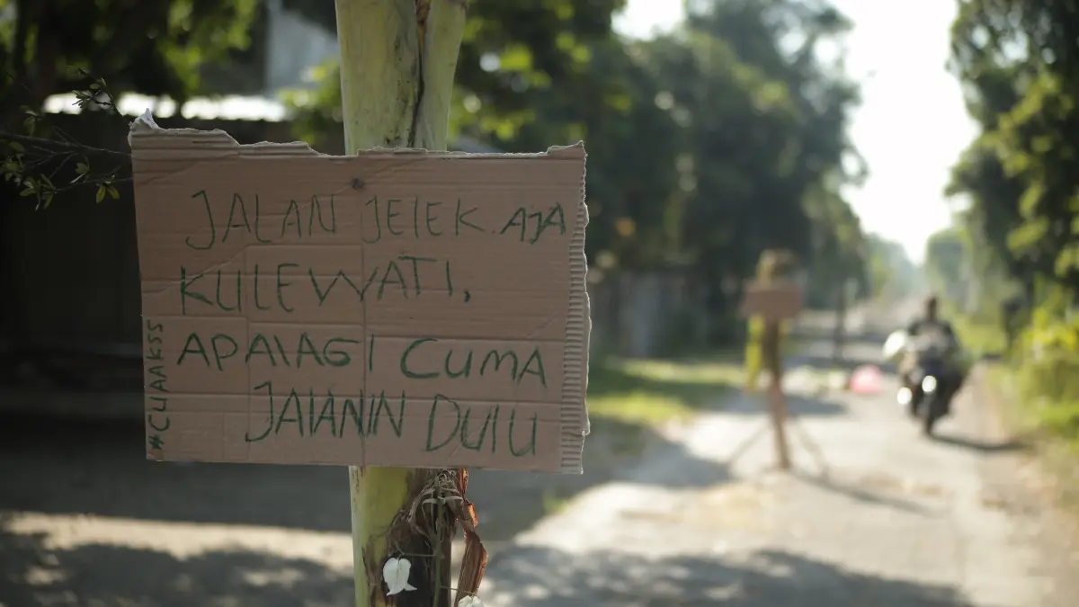 Warga memasang banner di sepanjang jalan desa di Desa Kelutan, Kecamatan Ngronggot yang rusak