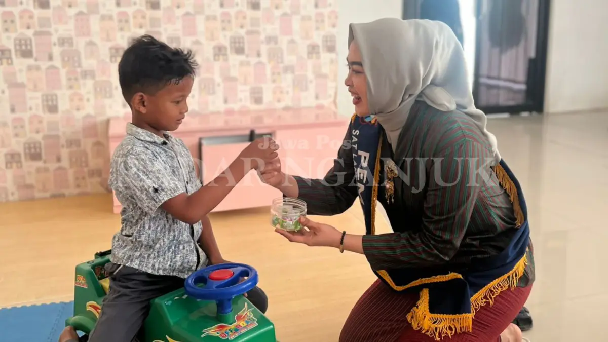 Polwan berpakaian baju adat memberi permen pada anak pemohon