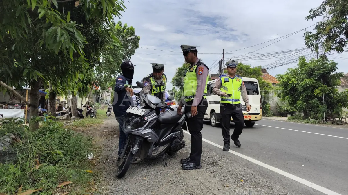 Petugas menghentikan pengendara motor pria yang menerobos saat razia gabungan