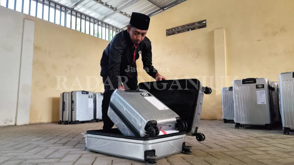 Petugas sedang mengecek koper yang akan dibawa CJH