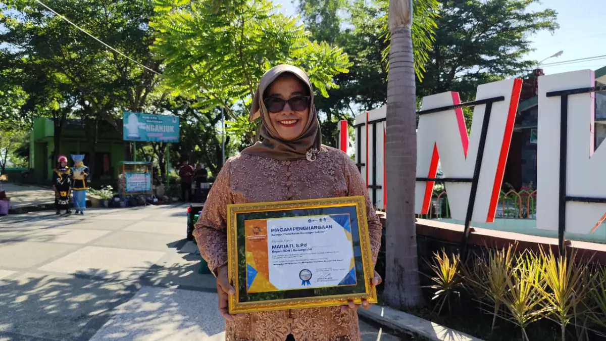 Mariati menunjukkan piagam penghargaan saat peringatan Hardiknas 2026