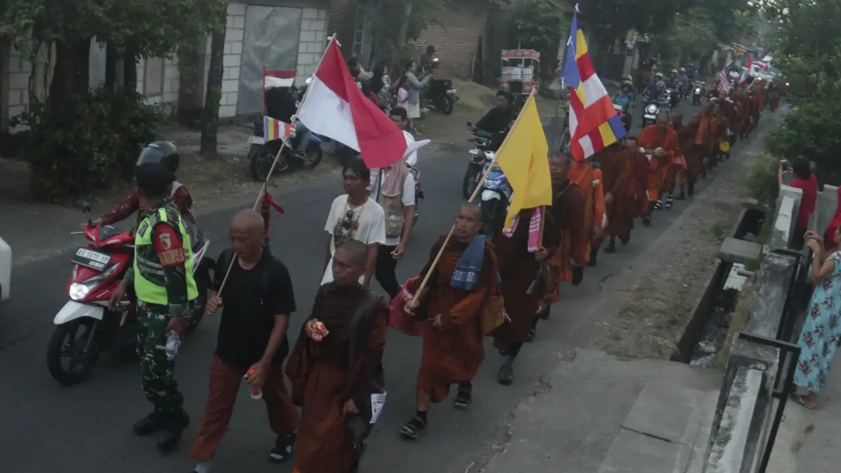 Puluhan biksu atau bhikku saat melewati jalan di Kecamatan Bagor