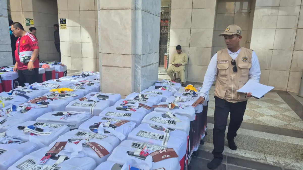 Petugas sedang mengecek koper jemaah