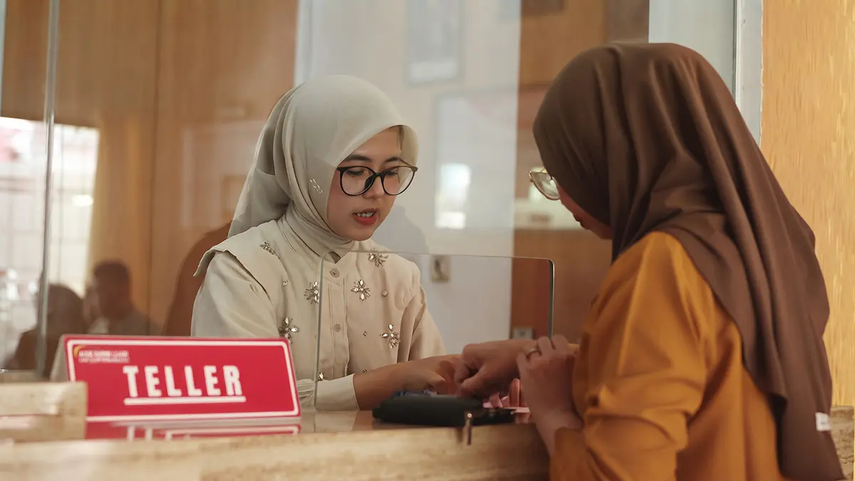 Teller BPR Anjuk Ladang sedang melayani nasabah.