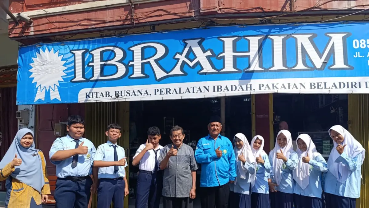 Kepala MTs Asyiyah Nganjuk Aris Nasution foto bersama di depan toko buku Ibrahim Nganjuk. 