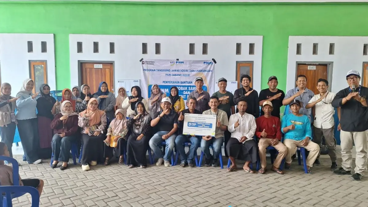 PEDULI LINGKUNGAN: PT Permodalan Nasional Madani (Persero) Kediri foto bersama warga Desa Karerban, Kecamatan Baron Nganjuk usai memberikan gerobak sampah dan tempat sampah. (FOTO: Dok PNM Kediri)